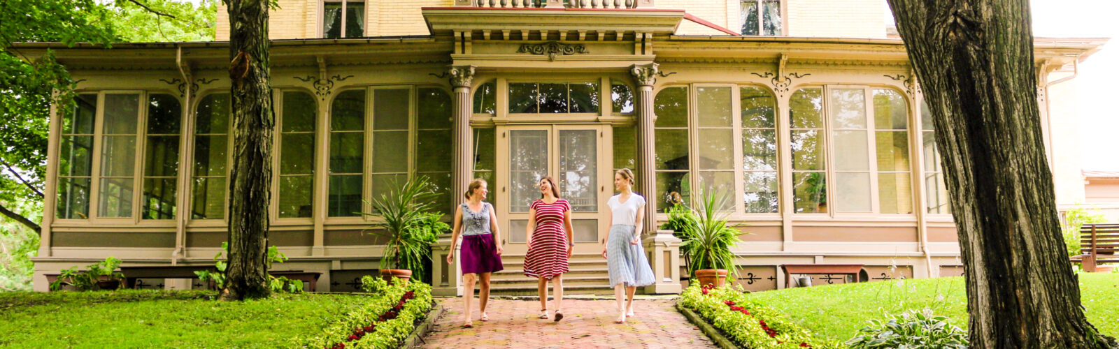 3 woman walking in front of Villa Louis building