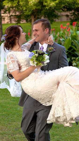 Groom holding his wife bridal style